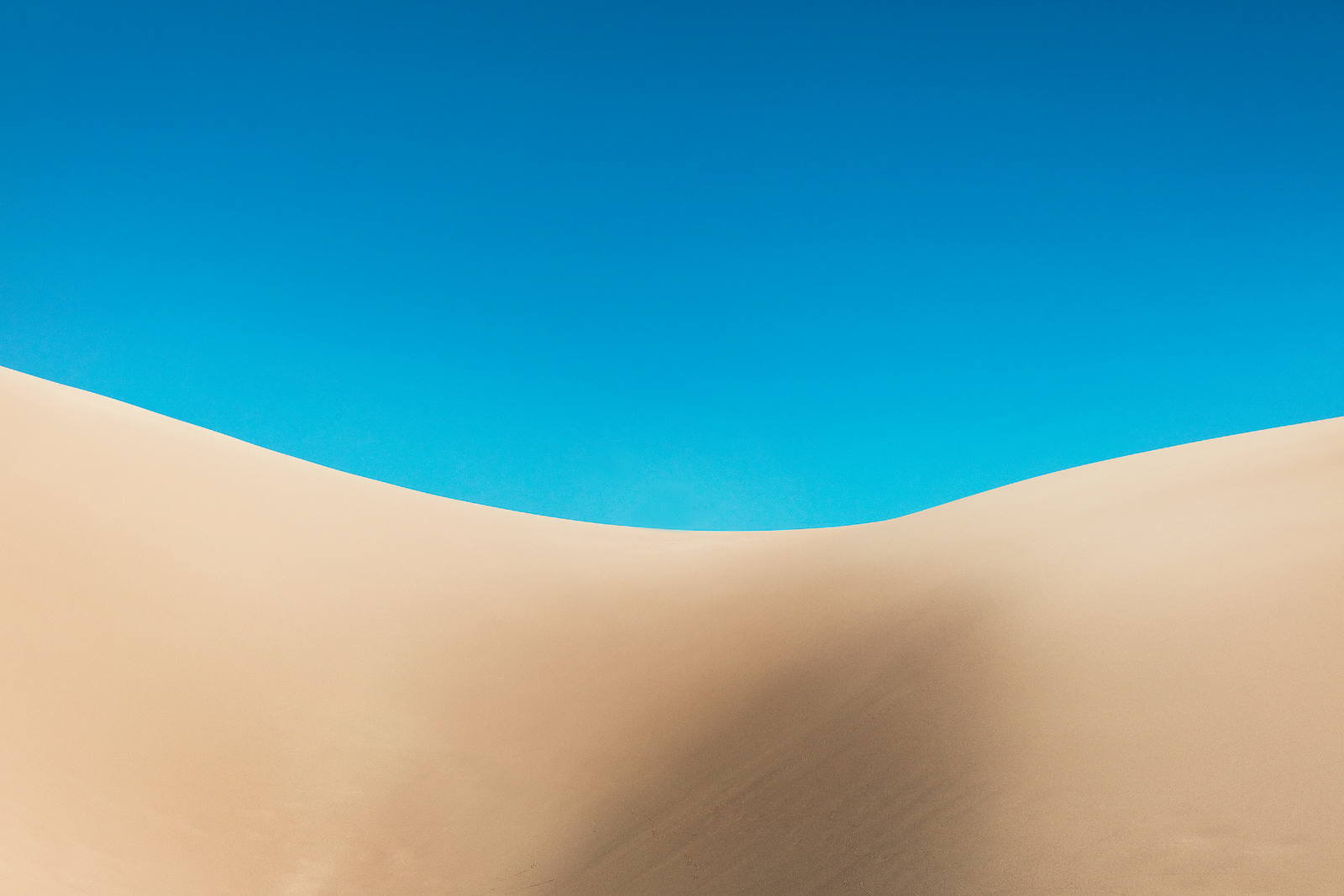giant sand dunes with bright blue sky behind at Great Sand Dunes National Park Colorado USA