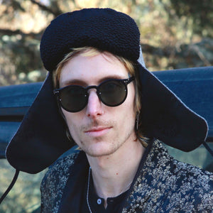 Image of a man wearing a Trapper of Colorado brand black and white wool stylish trapper hat with a black satin lining and black faux fur vegan Persian Lamb brim