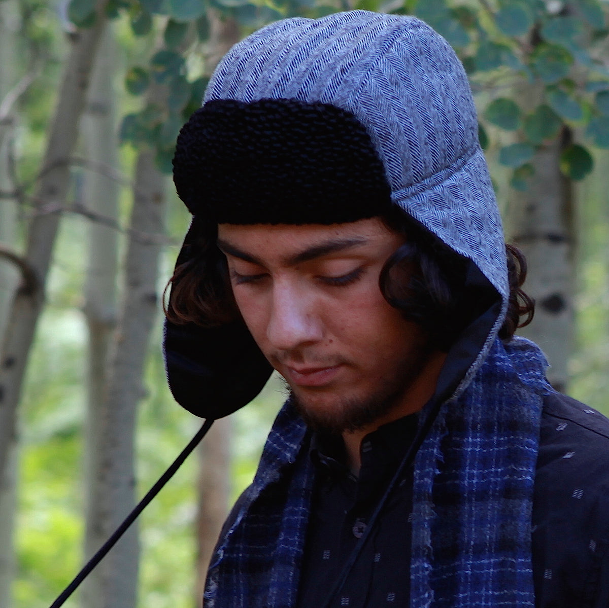 Image of a man wearing a Trapper of Colorado brand black and white wool stylish trapper hat with a black satin lining and black faux fur vegan Persian Lamb brim