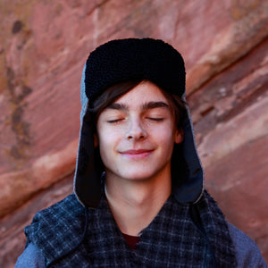 Image of a man wearing a Trapper of Colorado brand black and white wool stylish trapper hat with a black satin lining and black faux fur vegan Persian Lamb brim